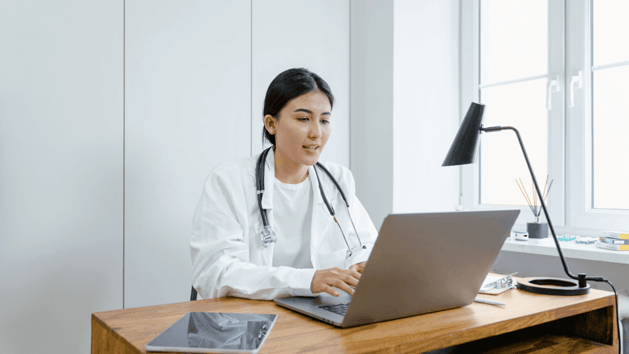 Medical Professional Using Laptop in Clinic